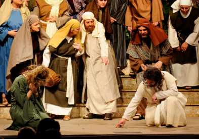 In a scene from East Auburn Baptist Church production of "The Event," Jesus, portrayed by Shawn DeGraff, writes in the dirt and asks the accusers, "He who is without sin, let him cast the first stone," when a woman caught in the act of adultery is brought before him, portrayed by Lisa Roy.